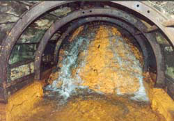 Acidic water pours over roof-high shale dam in No 9 adit, Cwmrheidol mine, 1992